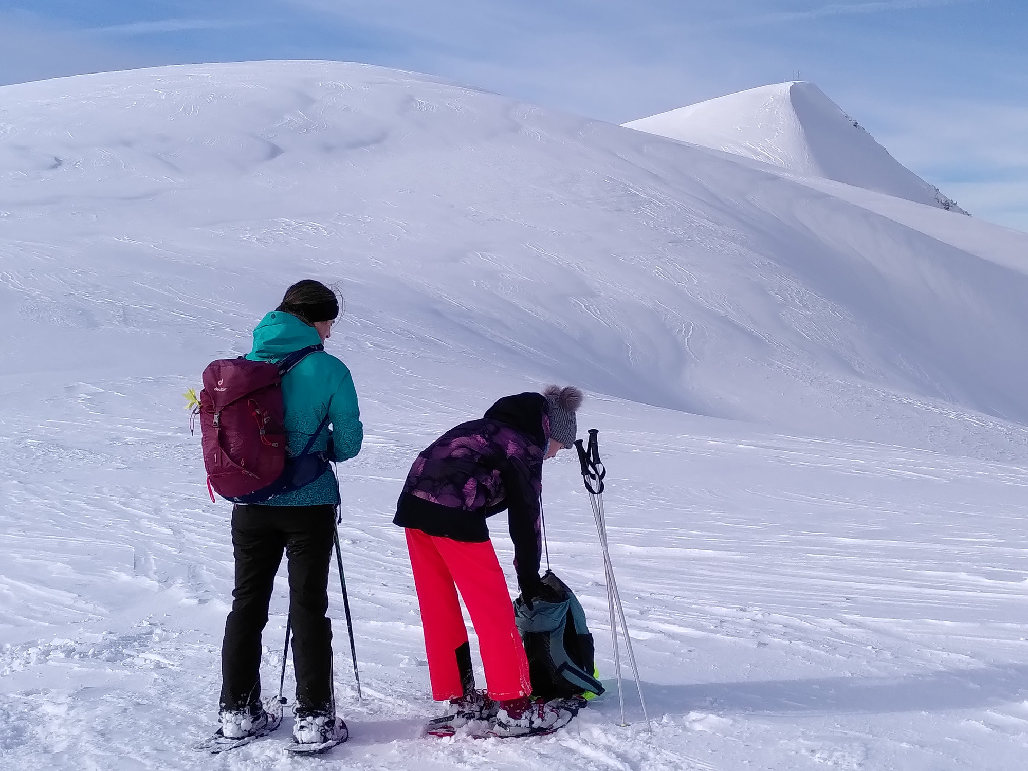 Zwei Personen der Schneeschuhgruppe machen eine kleine Pause in der atemberaubenden Umgebung. 