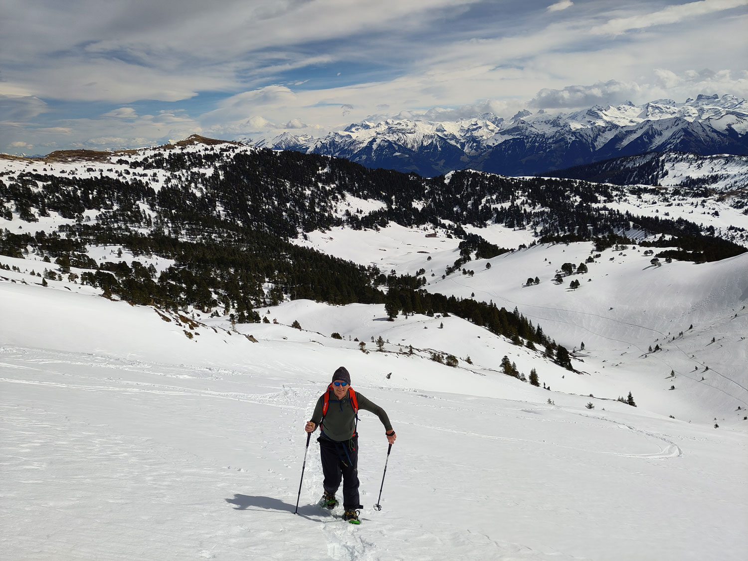 Wanderer beim Aufstieg mit Alpenpanorama im Hintergrund.